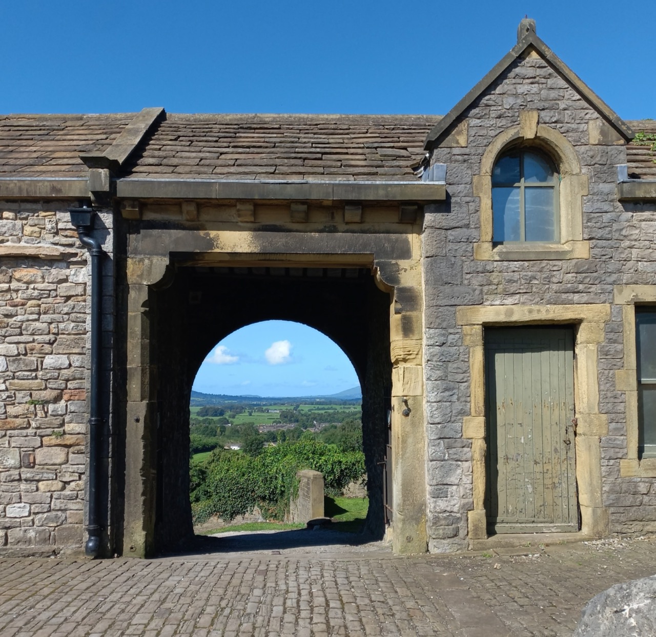 Stone gateway in Clitheroe Castle grounds with a view towards the countryside