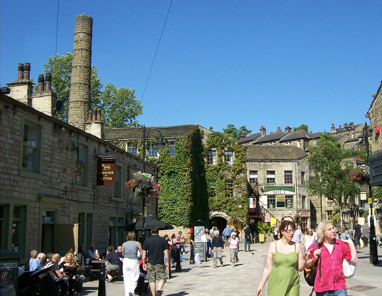 Stone buildings and people along Bridge Gate in Hebden Bridge