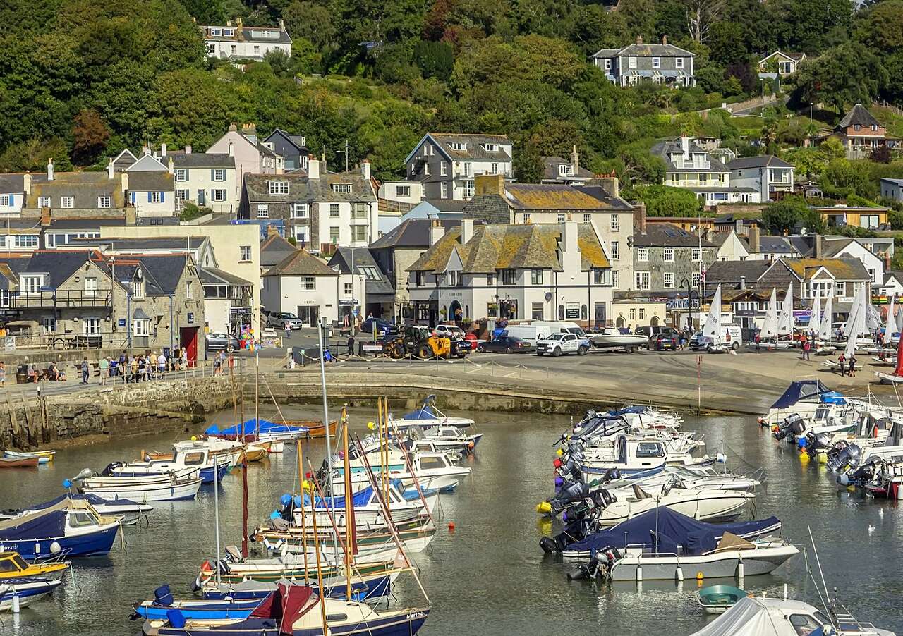 Boats in Lyme Regis harbour beneath the waterfront town